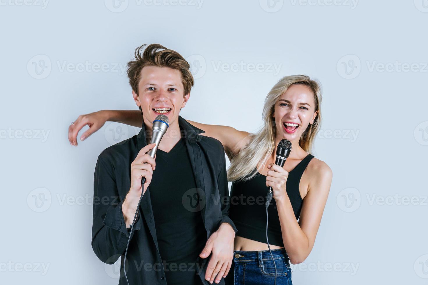 Happy portrait of couple holding microphones and singing photo