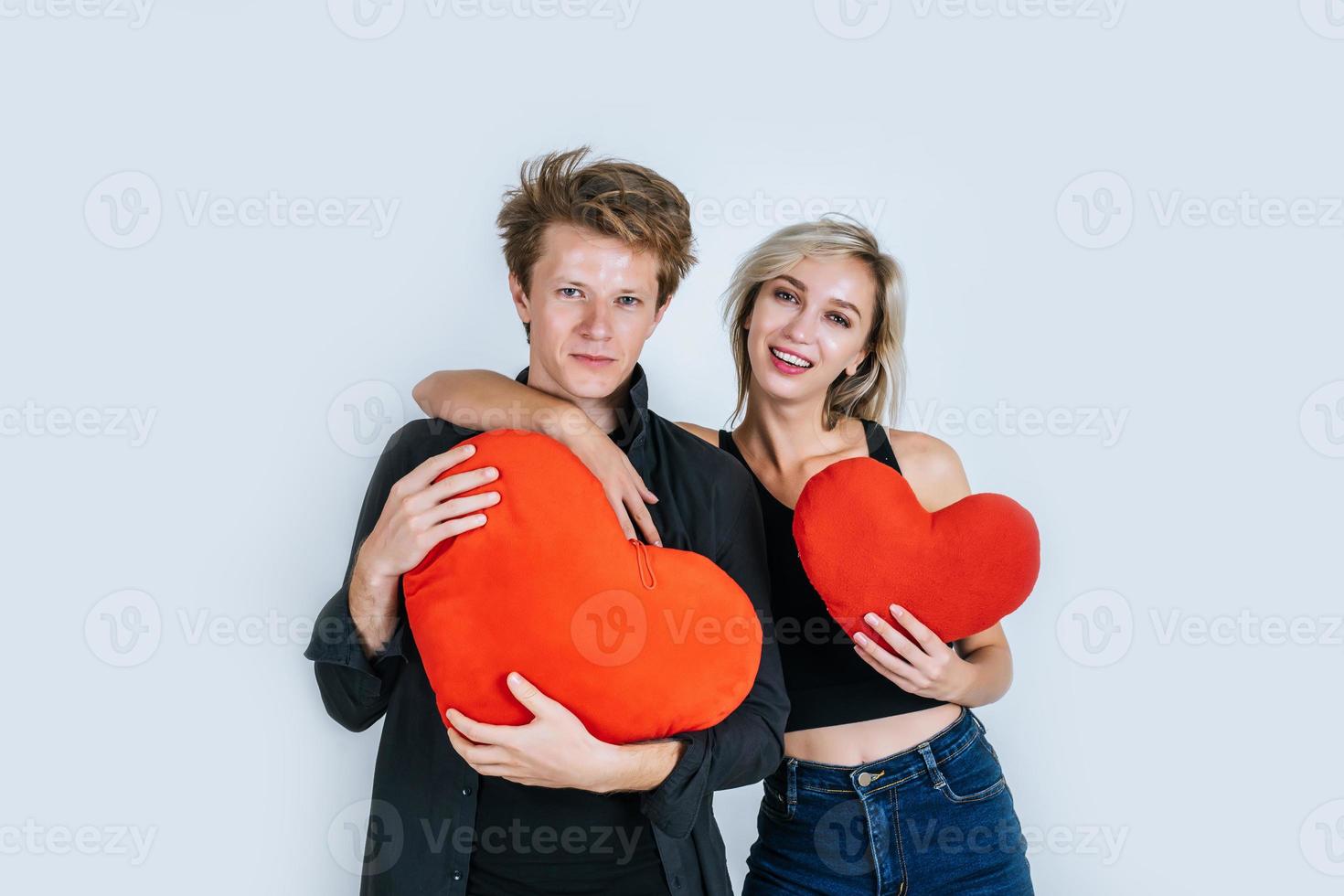 feliz pareja amorosa juntos sosteniendo un corazón rojo foto