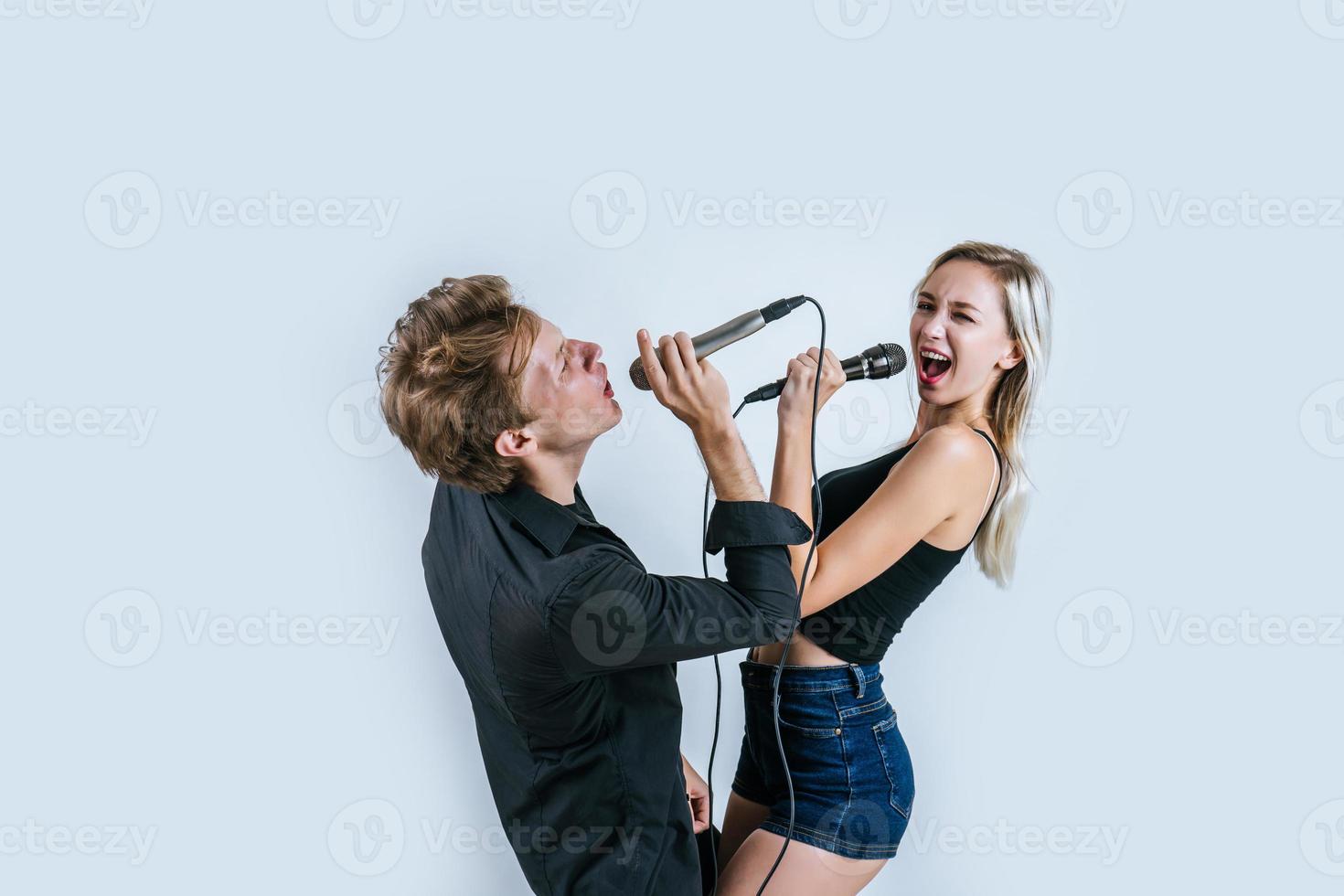 Happy portrait of couple holding microphones and singing photo