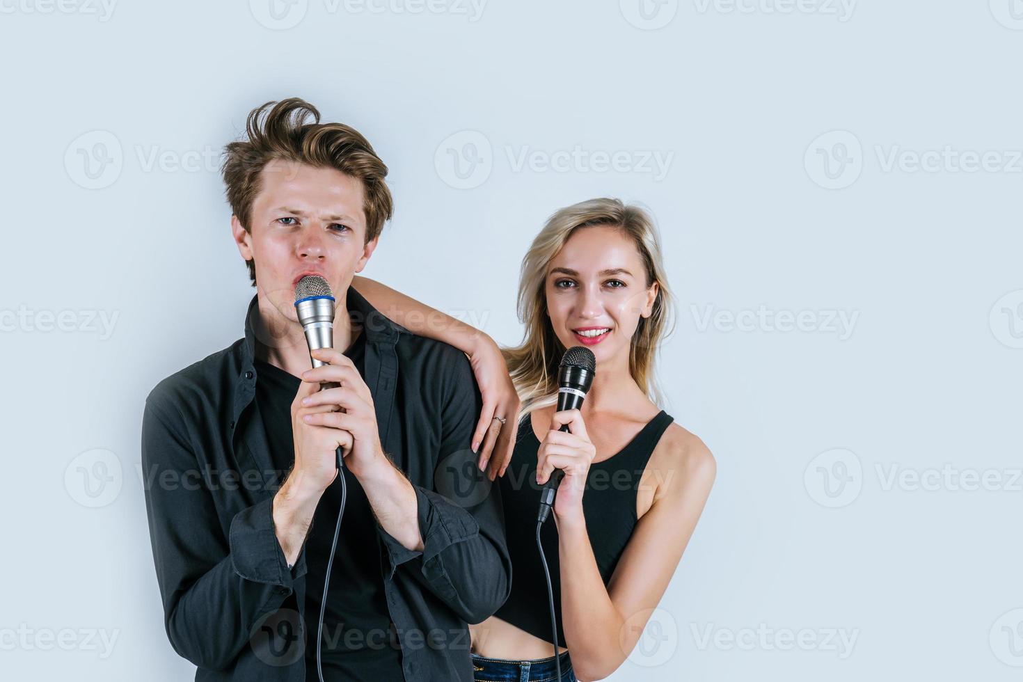 Happy portrait of couple holding microphones and singing photo