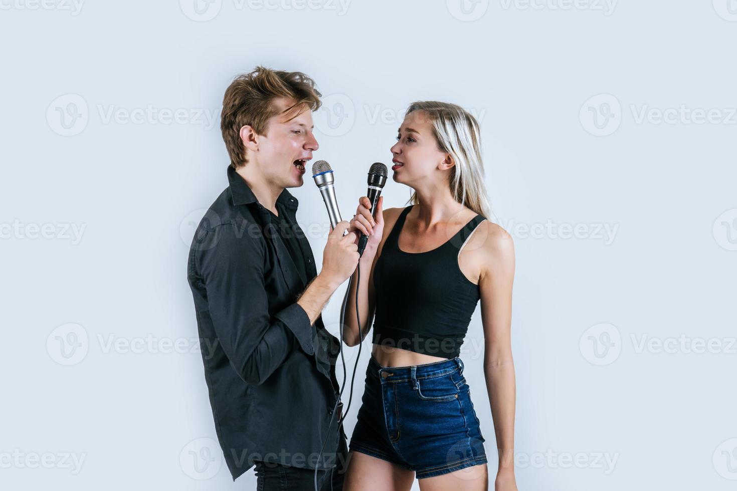 Happy portrait of couple holding microphones and singing photo