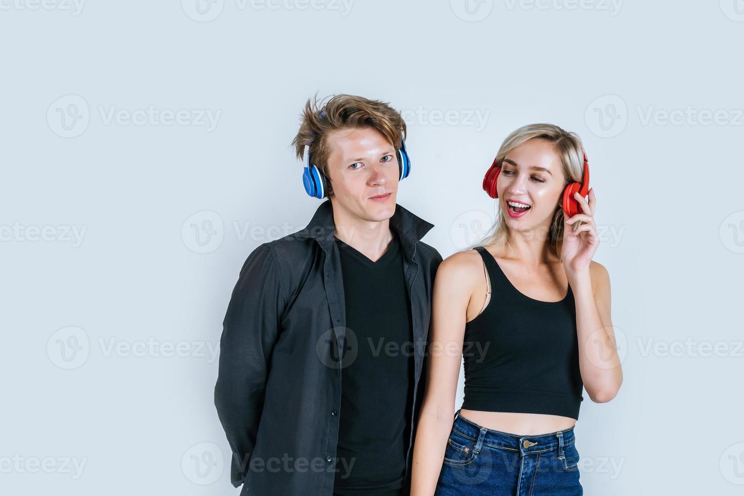 Feliz pareja joven en auriculares escuchando música en el estudio foto