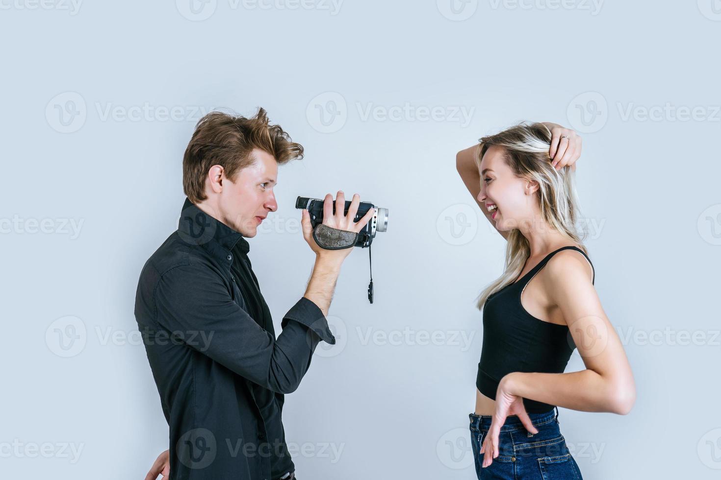 Happy portrait of couple holding video camera and recording a video photo