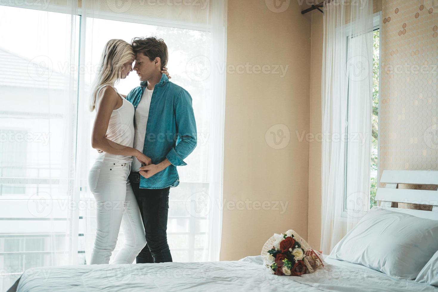 feliz pareja abrazada en el dormitorio foto