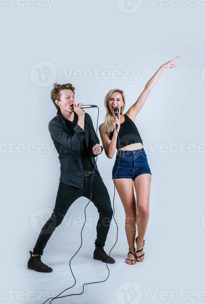 Happy portrait of couple holding microphones and singing photo