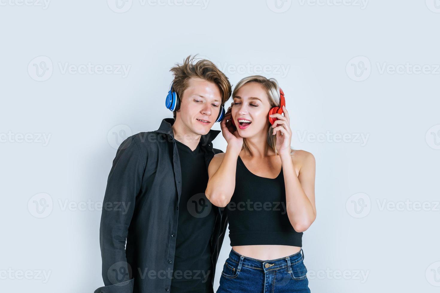 Feliz pareja joven en auriculares escuchando música en el estudio foto