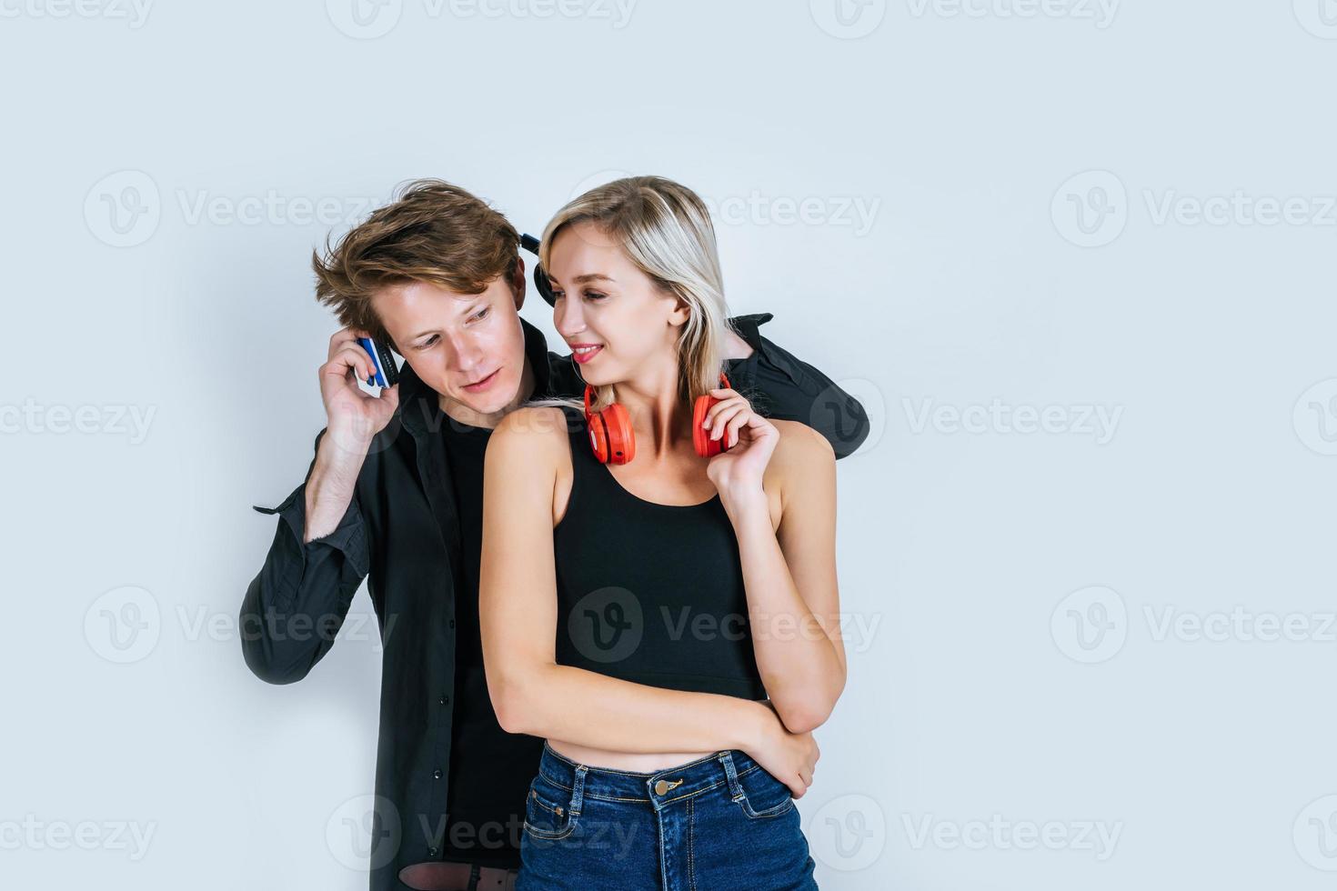 Happy young couple in headphones listening music in studio photo