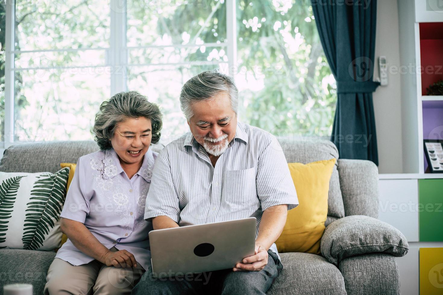 Senior couple talking and using laptop computer photo