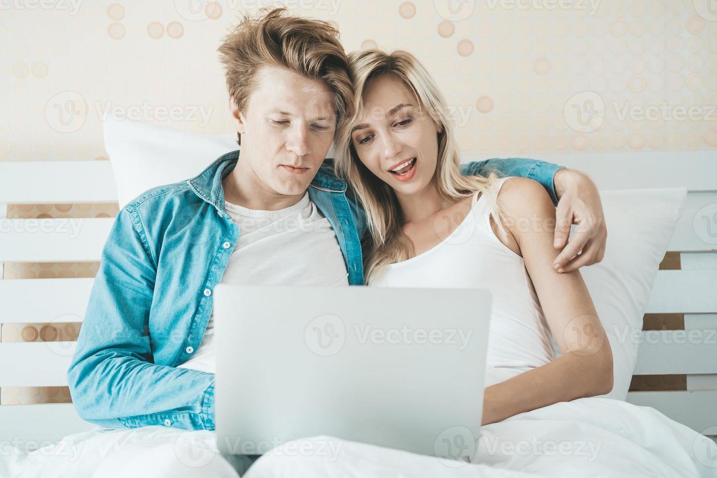 pareja feliz, usar la computadora portátil, computadora portátil, en la cama foto