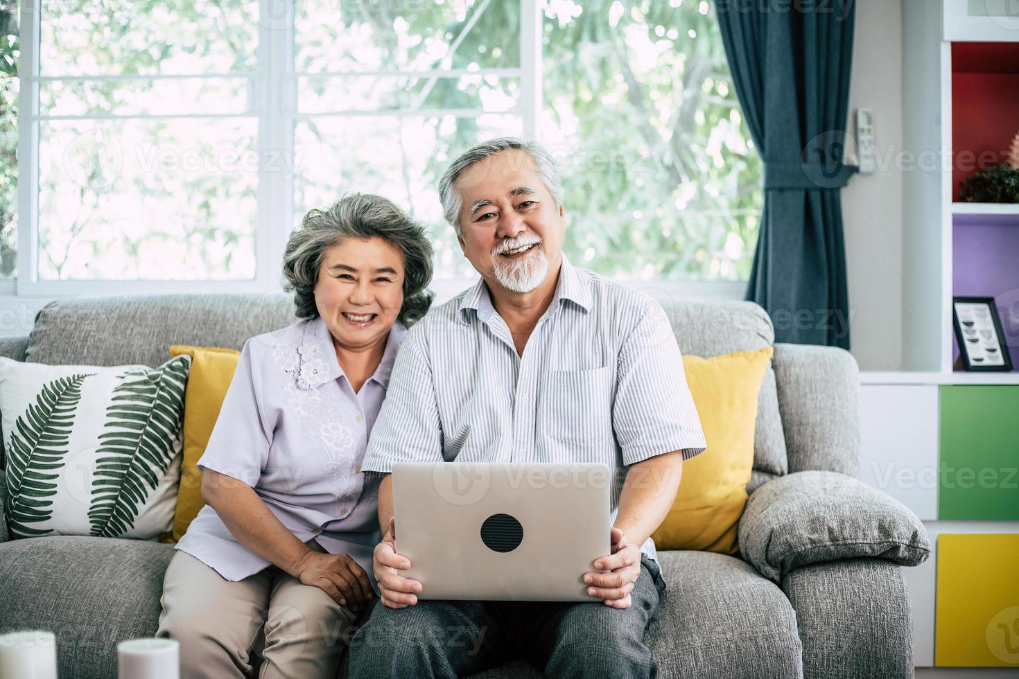 pareja mayor, hablar, y, utilizar la computadora portátil foto