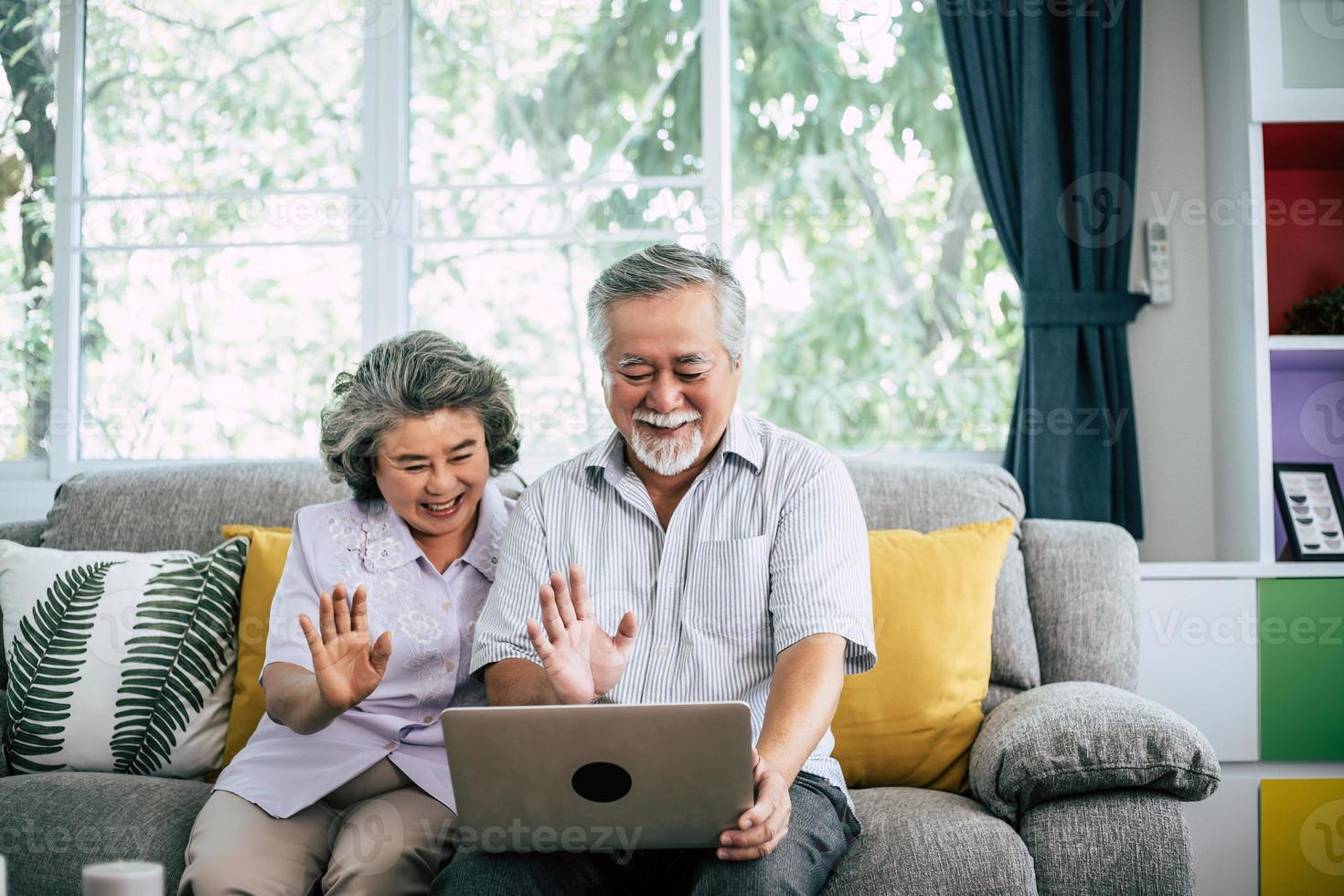 Senior couple talking and using laptop computer photo