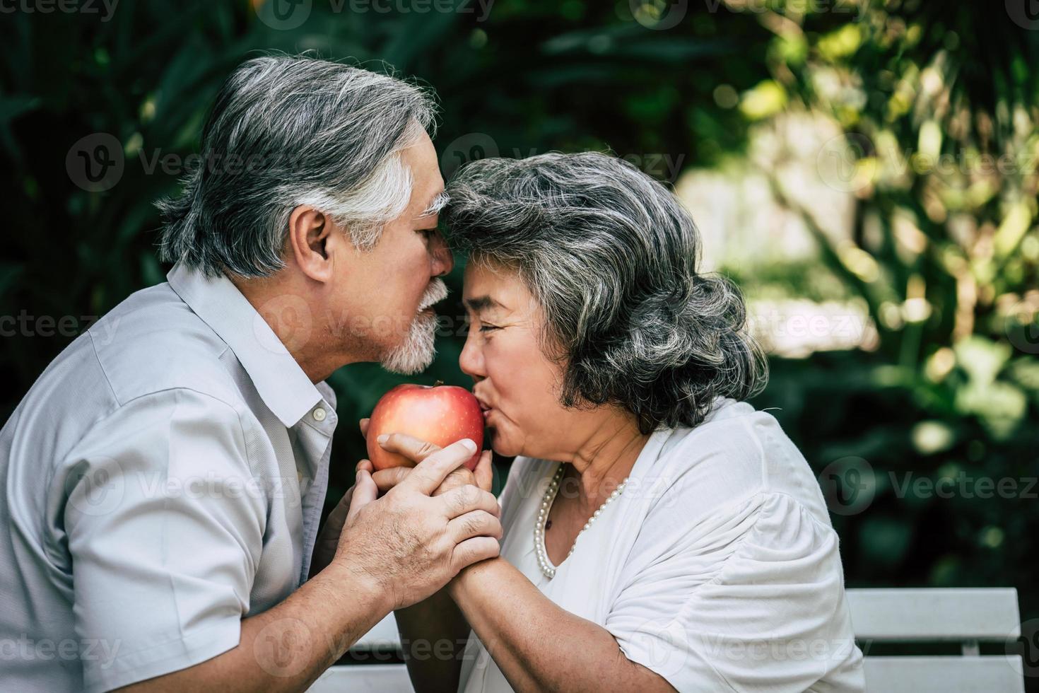 Elderly couple playing and eating some fruit photo