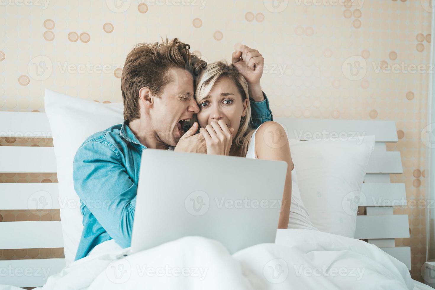 pareja feliz, usar la computadora portátil, computadora portátil, en la cama foto