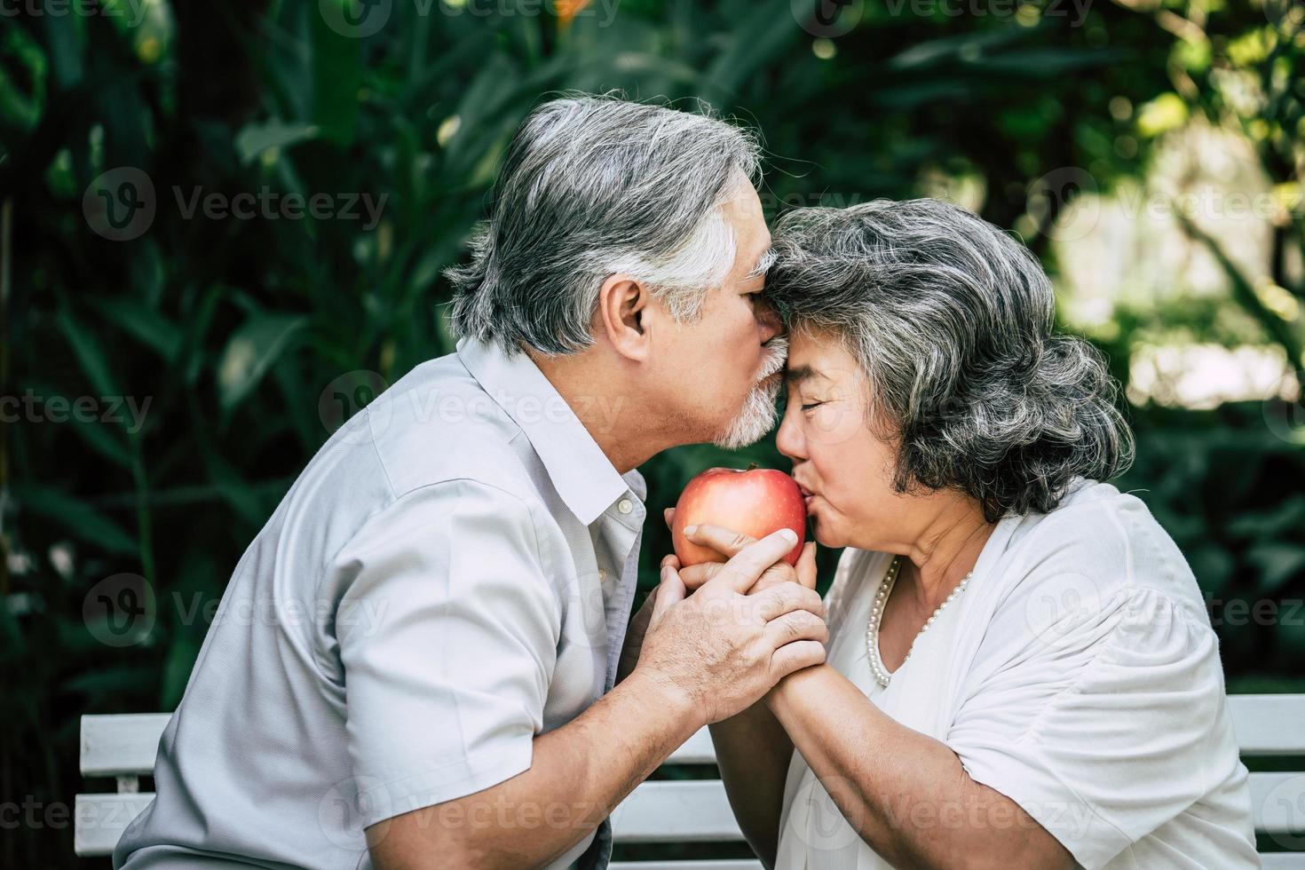 Elderly couple playing and eating some fruit photo