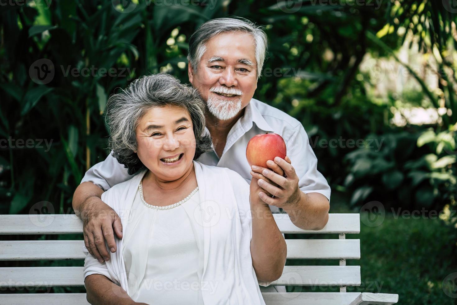 pareja de ancianos jugando y comiendo fruta foto