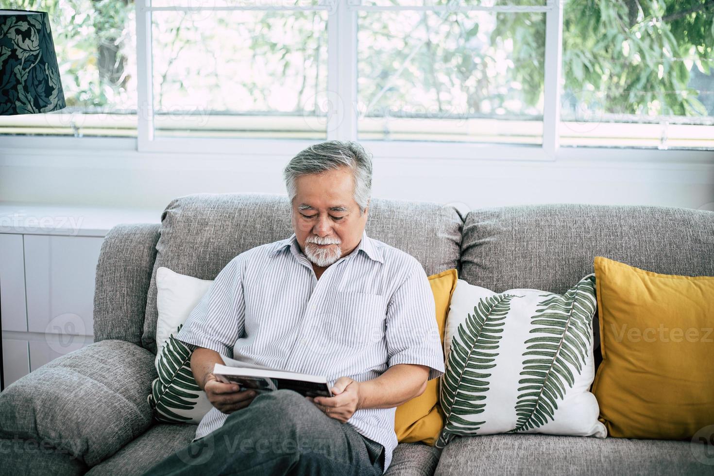 Old man reading in living room photo