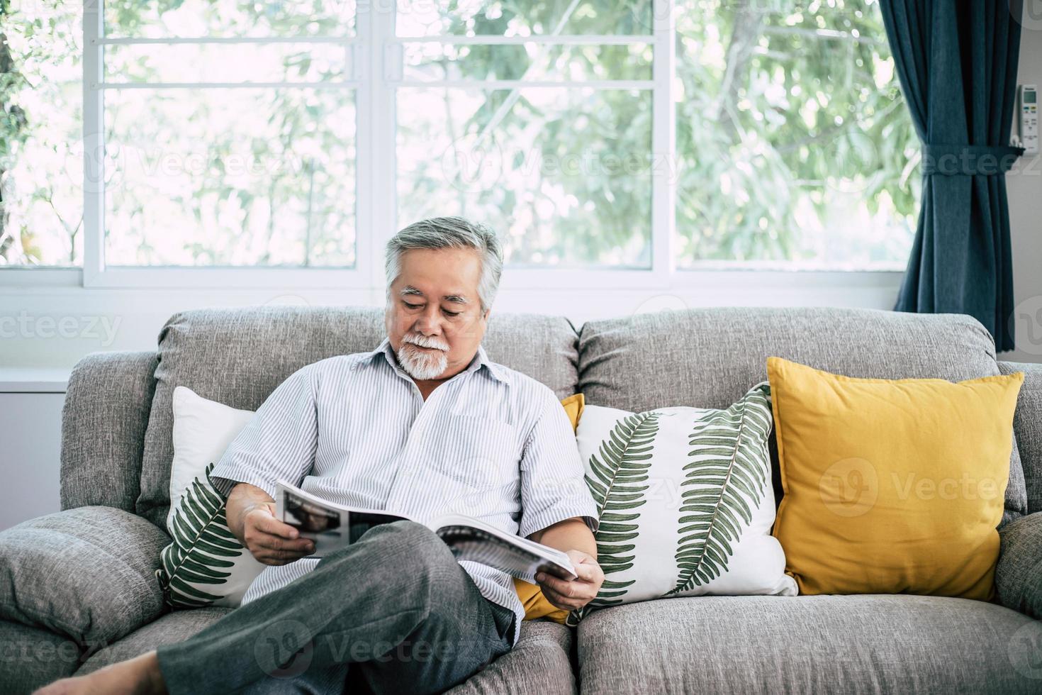 Old man reading in the living room photo
