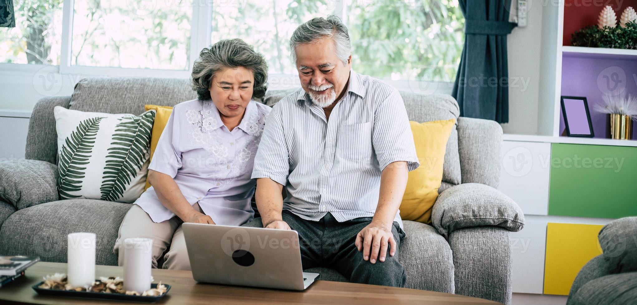 Senior couple talking and using laptop computer photo