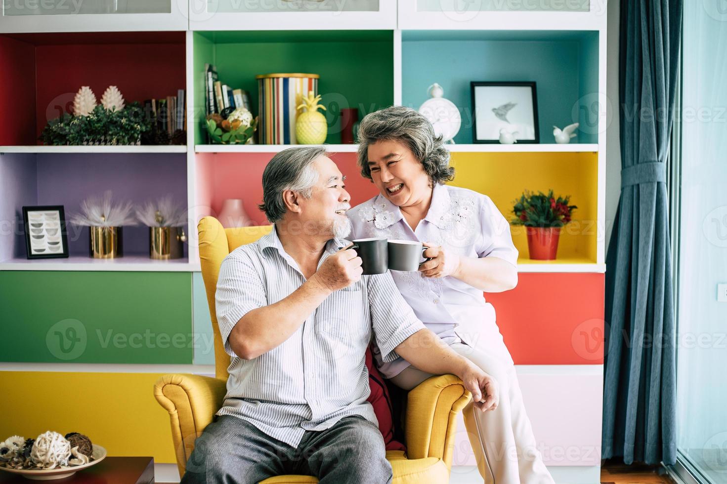 Elderly couple talking together and drinking coffee or milk photo