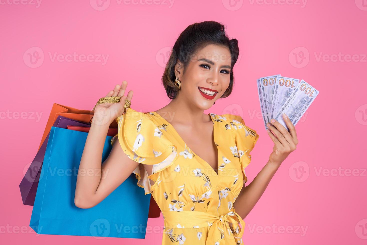 Happy F fashionable woman holding money for shopping photo