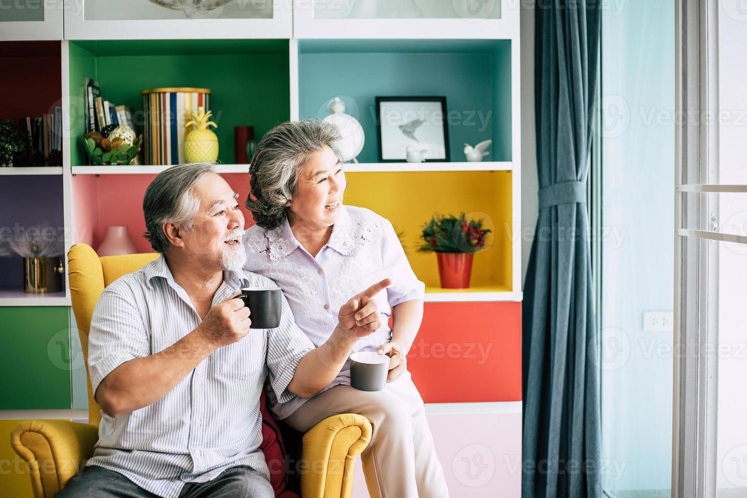 Elderly couple talking together and drinking coffee or milk photo