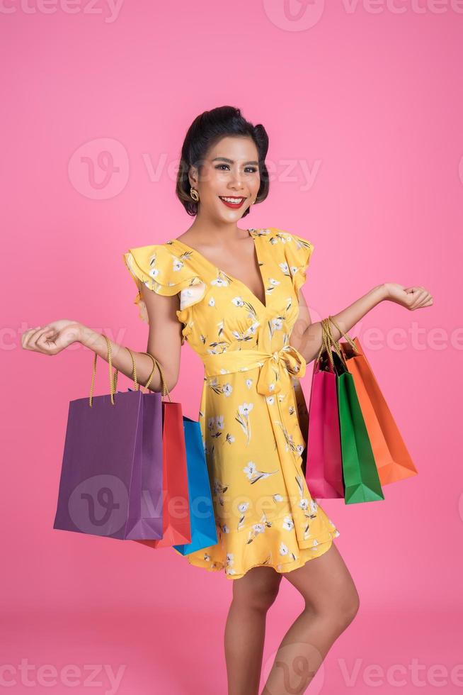 Beautiful Asian woman holding colored shopping bags photo