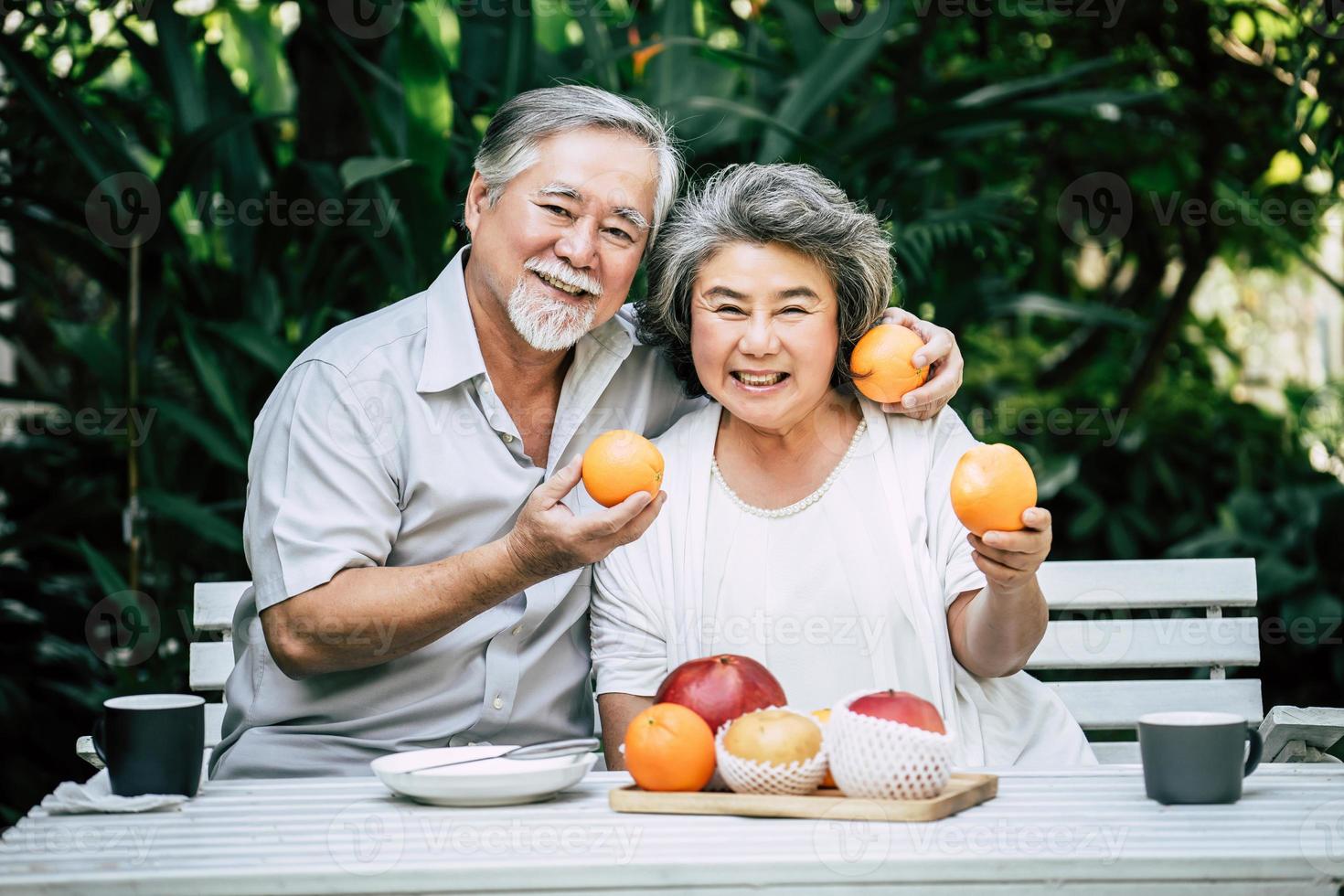 pareja de ancianos jugando y comiendo fruta foto