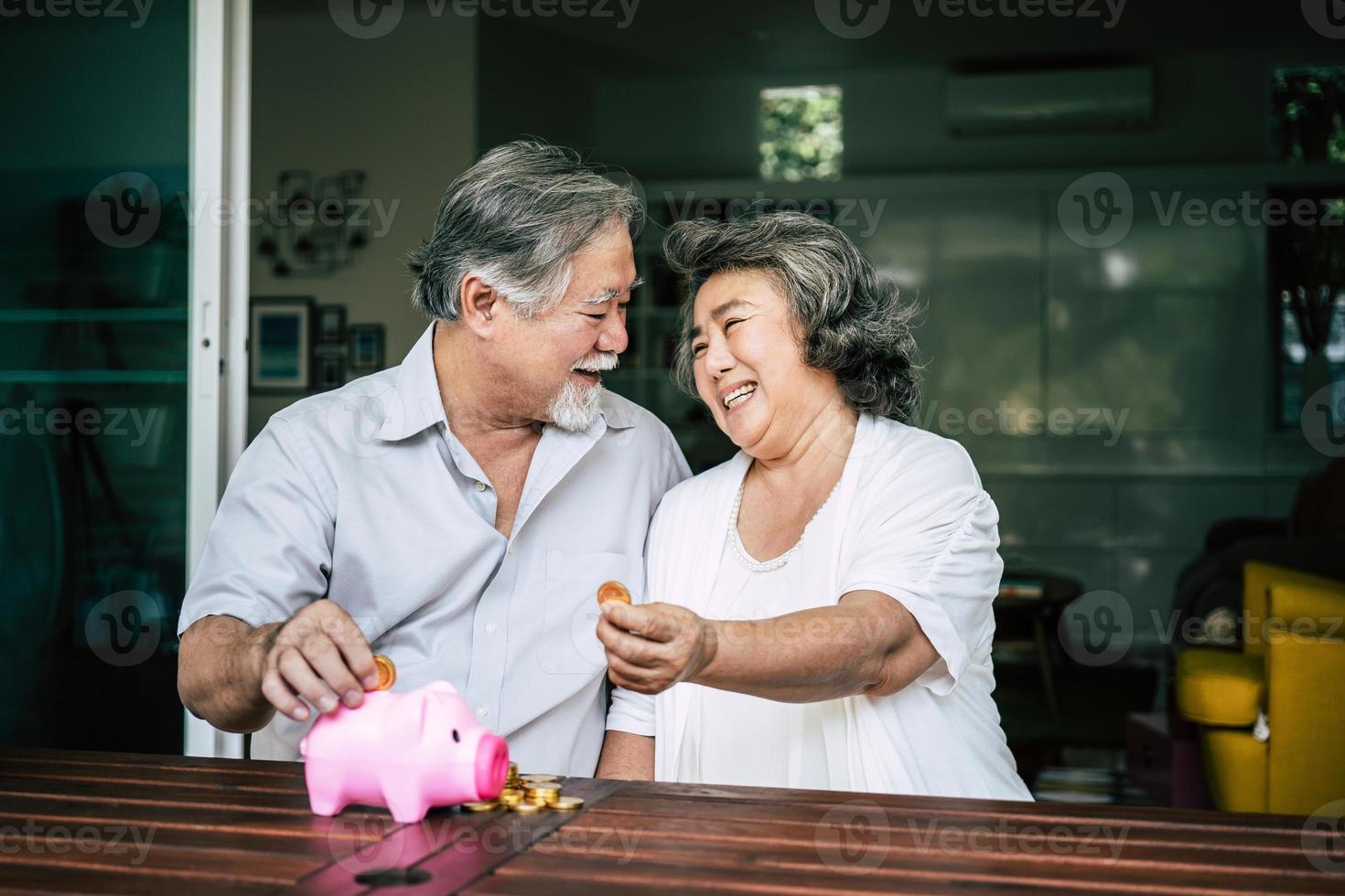 Elderly couple talking about finances with piggy bank photo