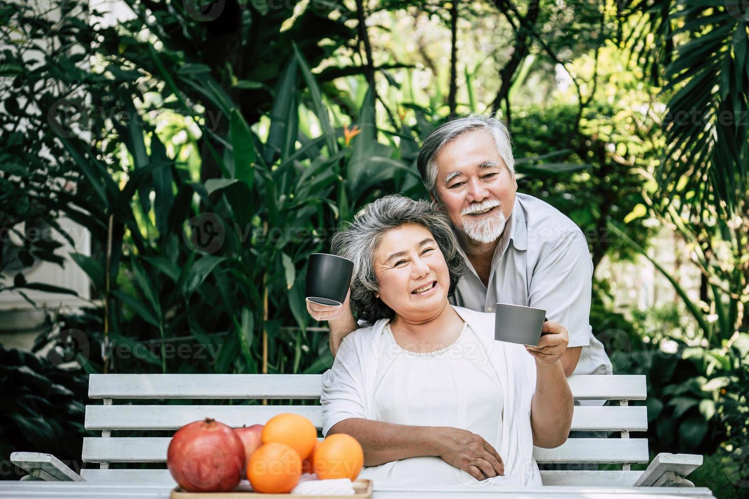 Elderly couple playing and eating some fruit photo