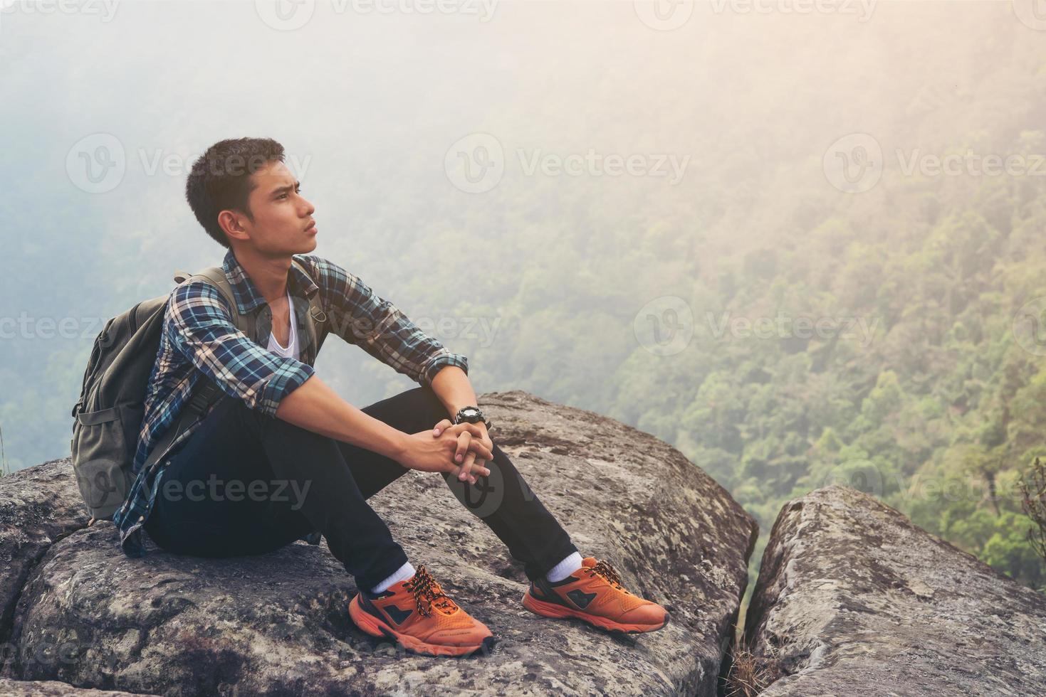 Young hipster man take a rest in the mountain top. Travel lifestyle concept. photo