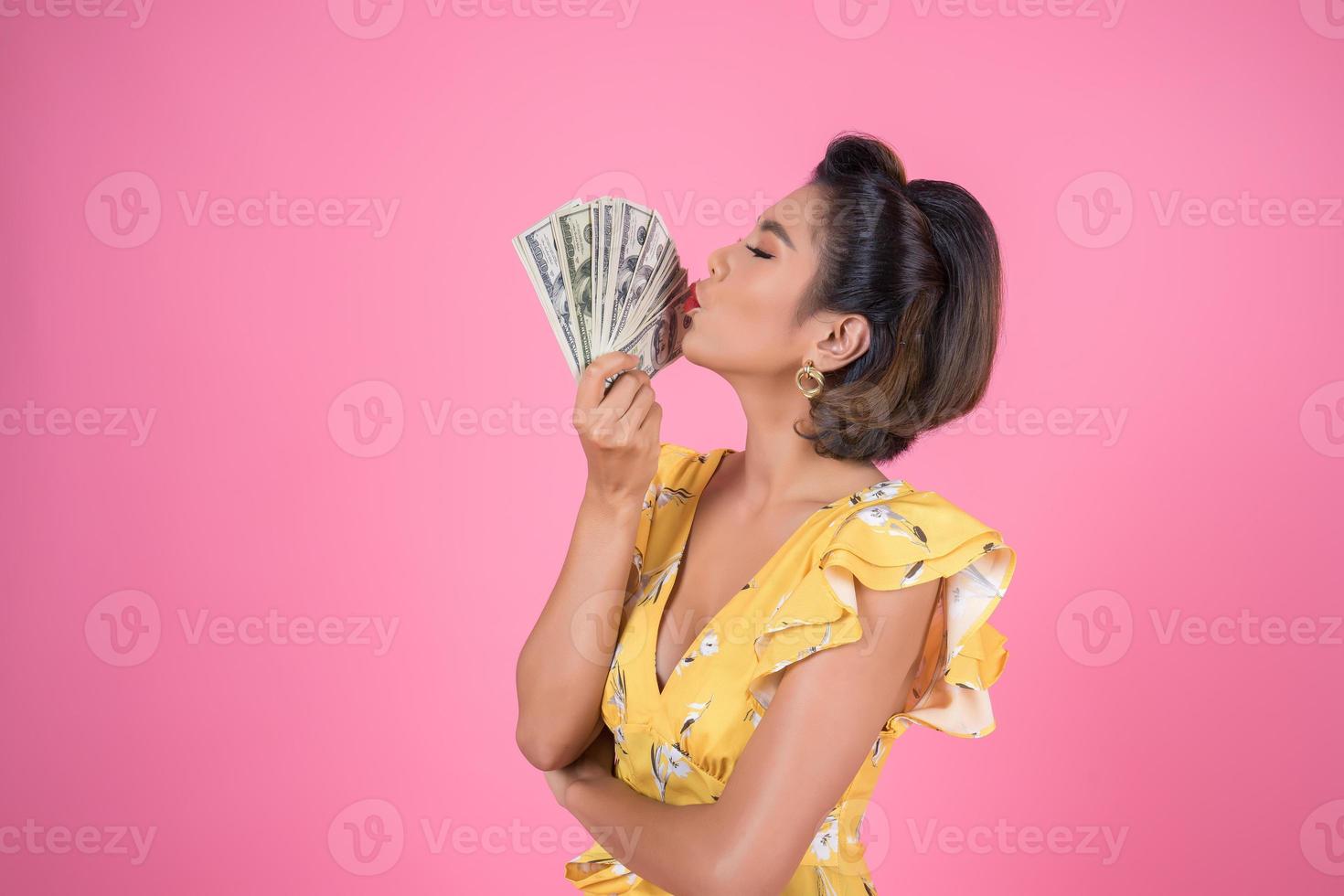 feliz mujer de moda con dinero para ir de compras foto