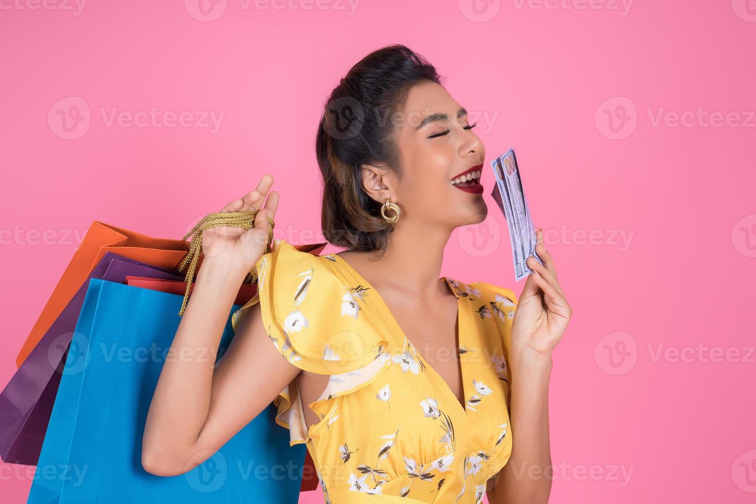 feliz mujer de moda con dinero para ir de compras foto