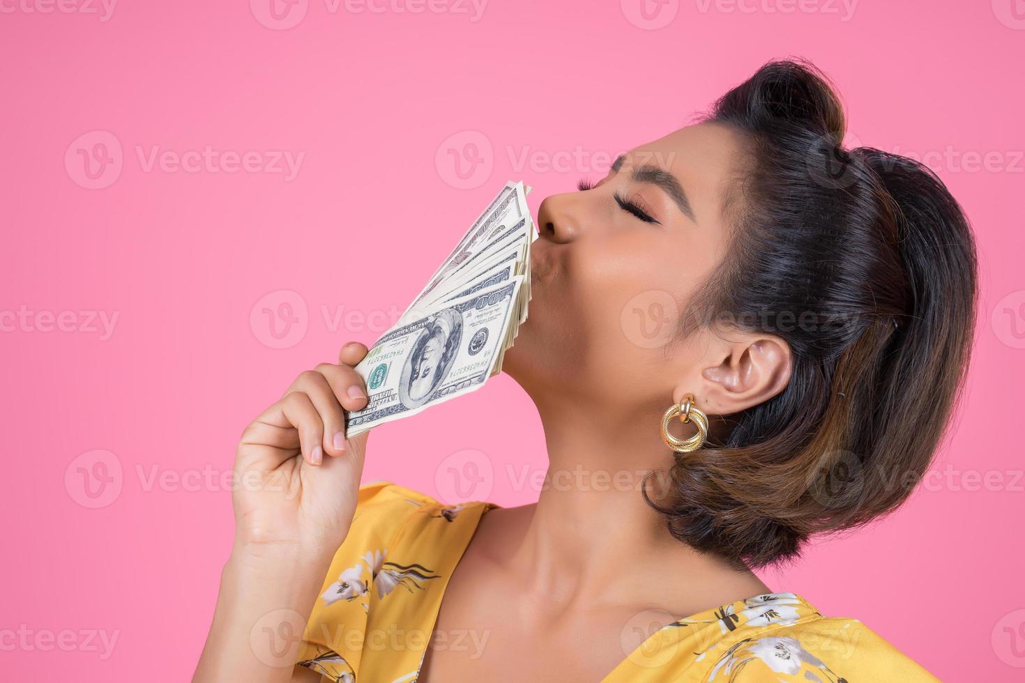 Happy fashionable woman holding money for shopping photo