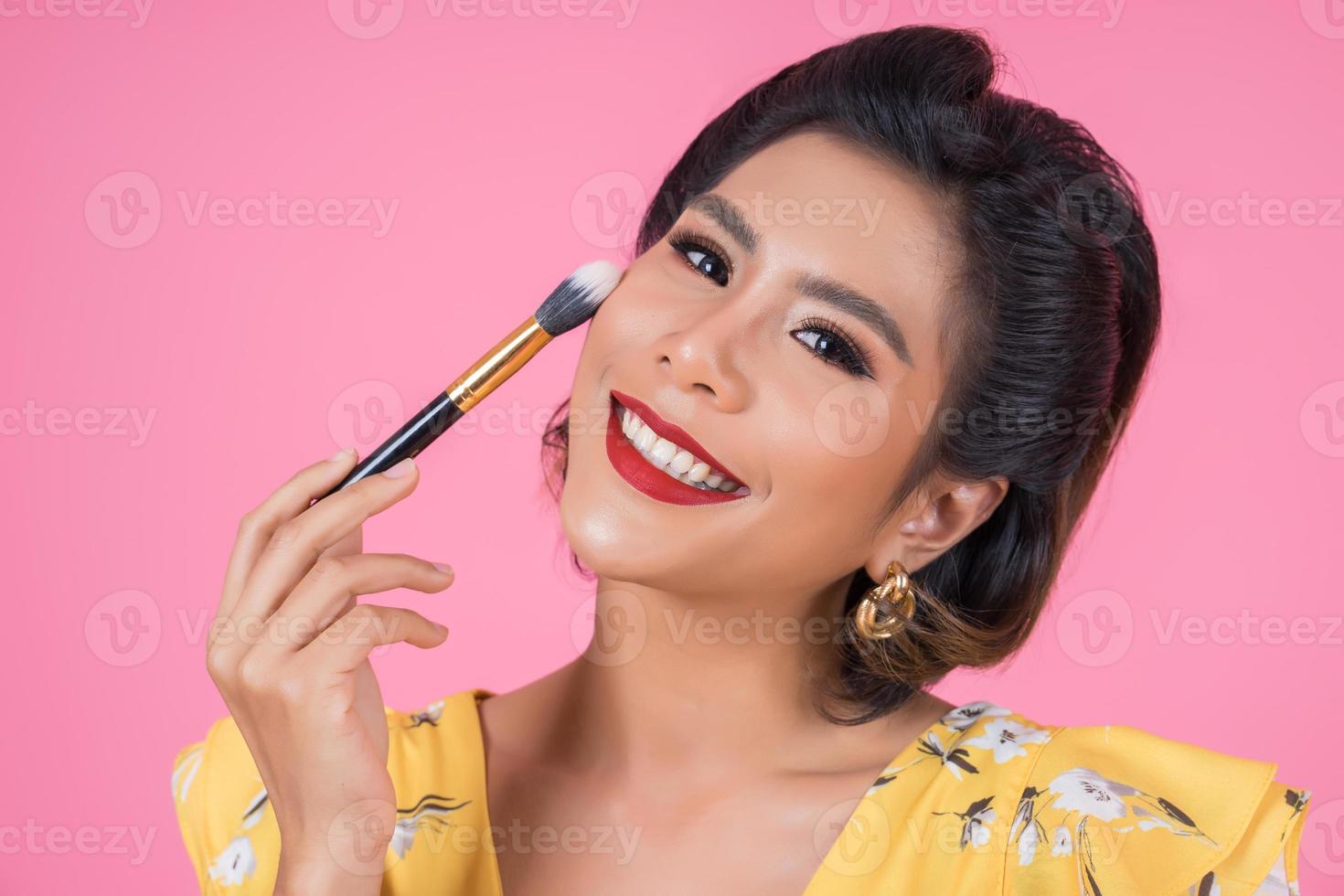 Portrait of a woman with makeup brush photo