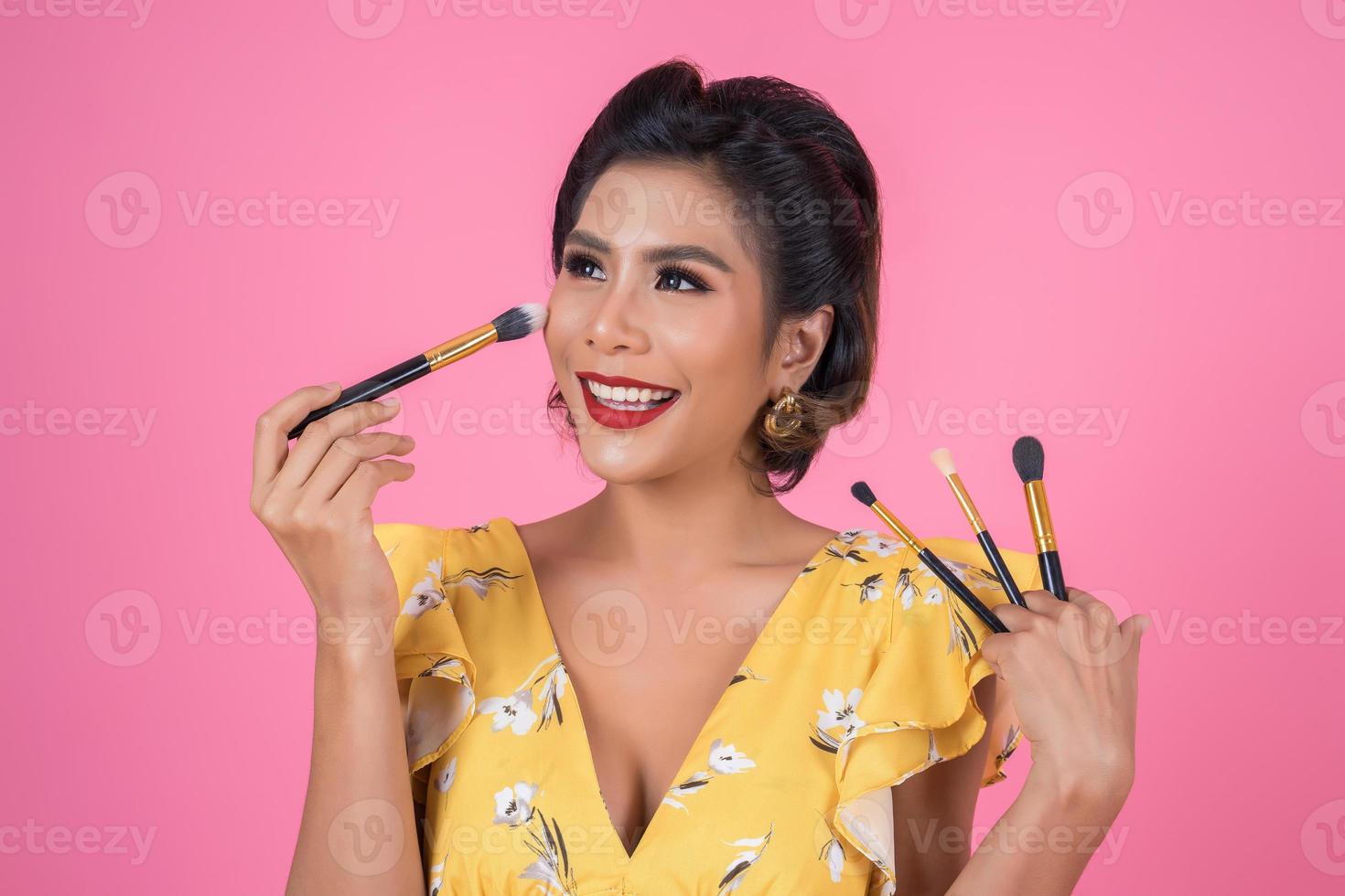 Portrait of a woman with makeup brush photo