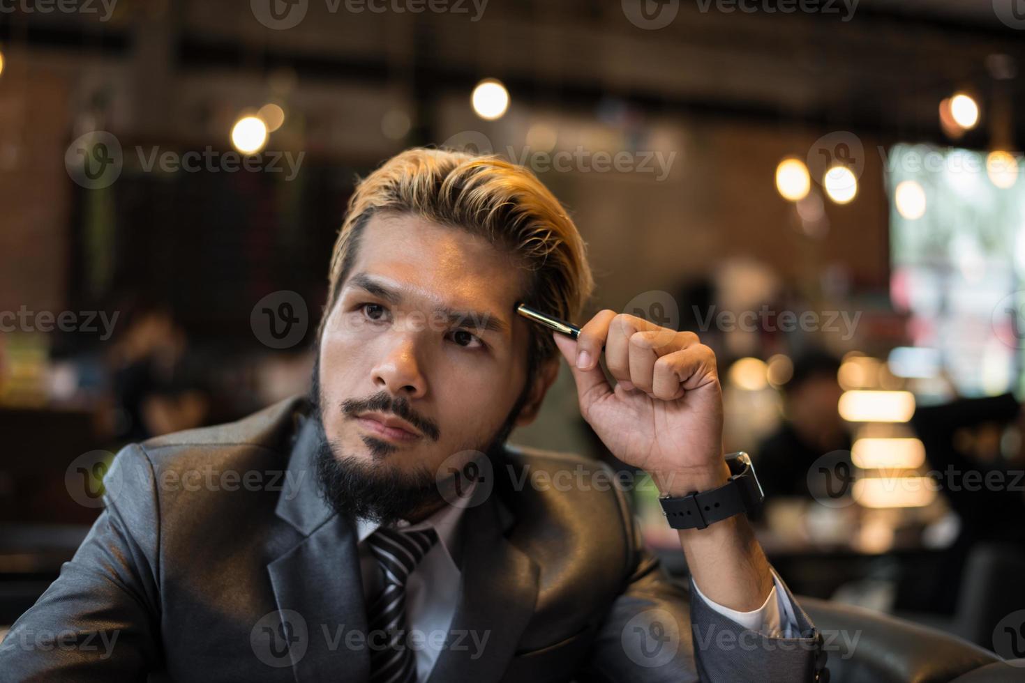 Handsome businessman thinking about work while working at cafe photo