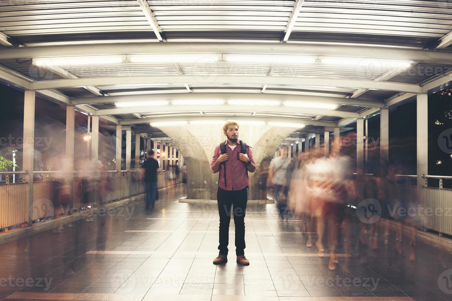 Handsome bearded man with backpack standing on the street traveling at night photo