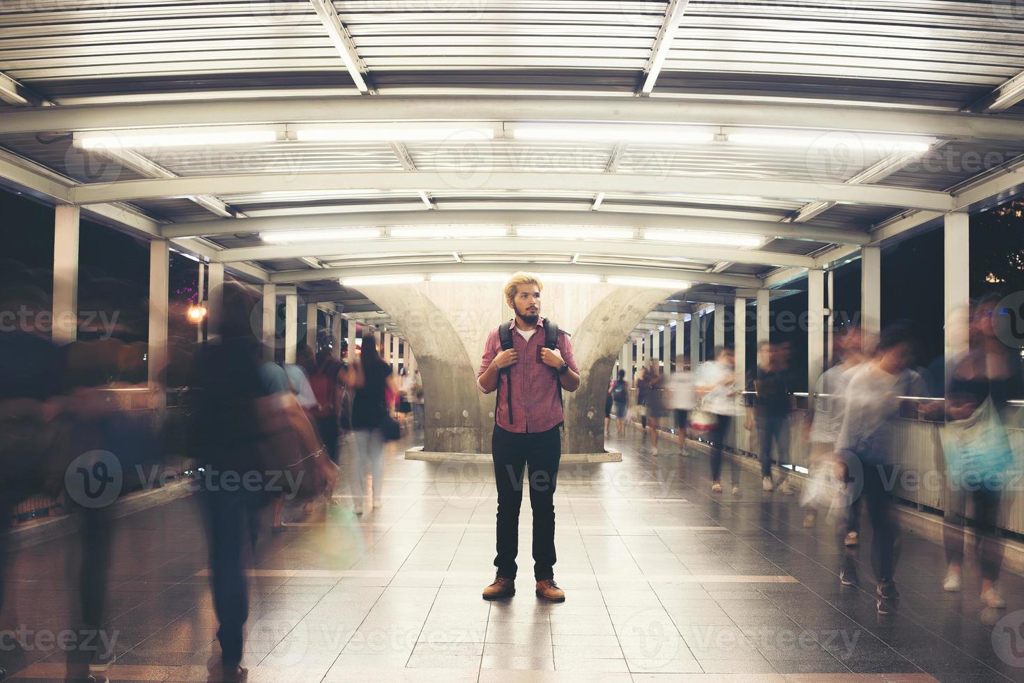 Handsome bearded man with backpack standing on the street traveling at night photo