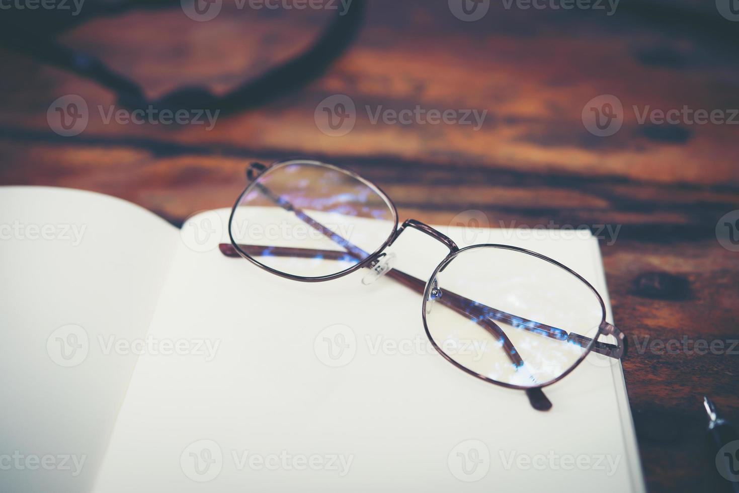 Workspace desk with glasses and notebook with copy space background photo