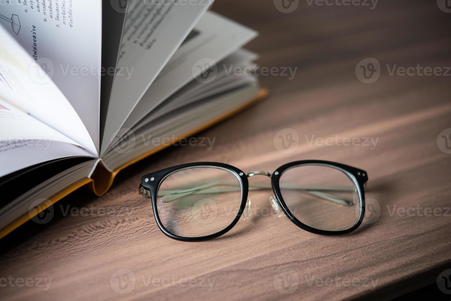 Pile of book and glasses on the wooden table photo