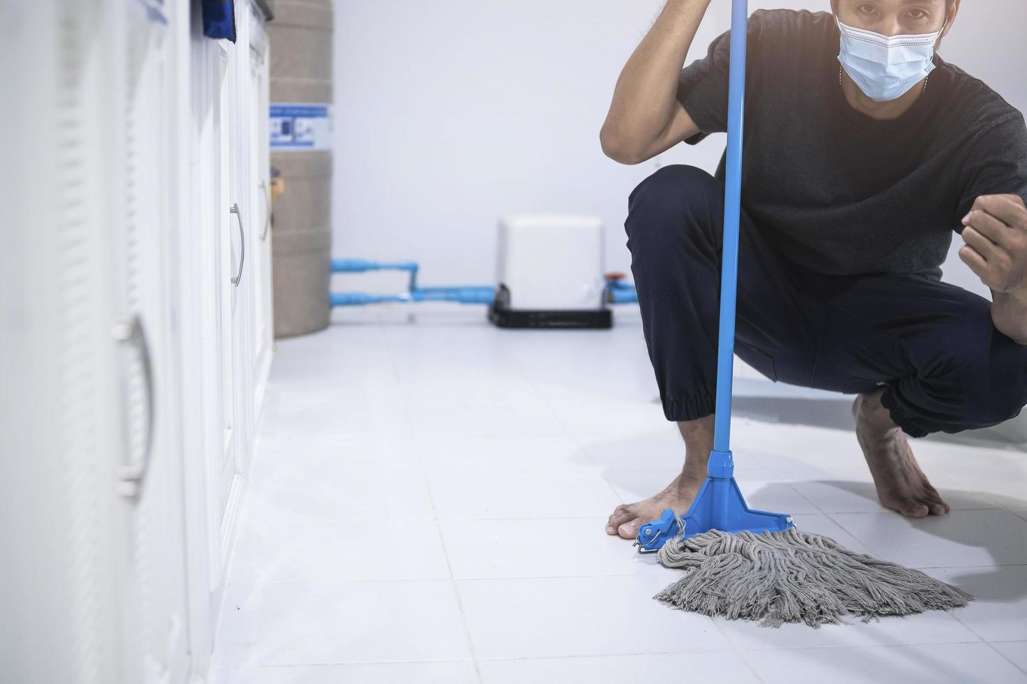 Asian man cleaning with a mop photo