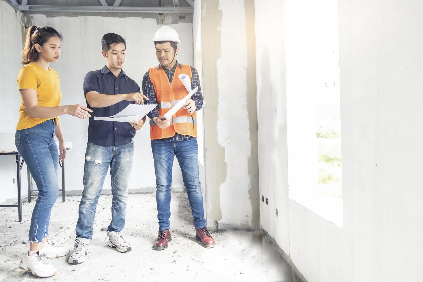 jóvenes ingenieros asiáticos construyendo una casa foto