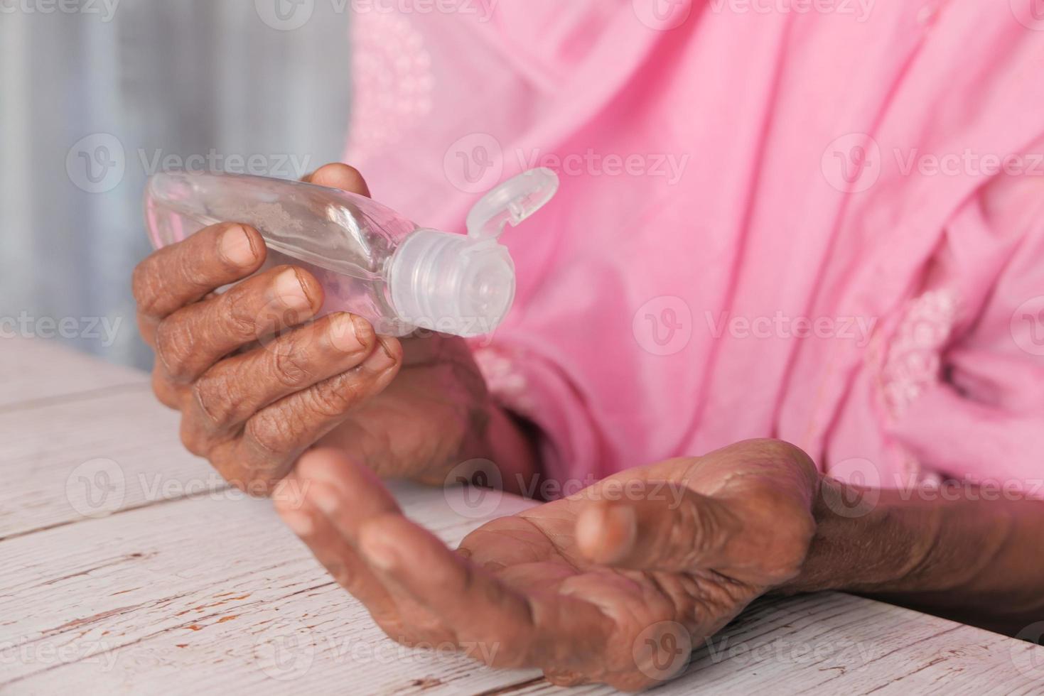 Old person using hand sanitizer photo