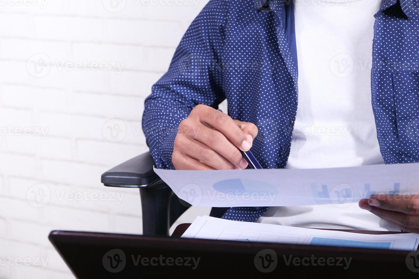 Man looking at a piece of paper with charts photo