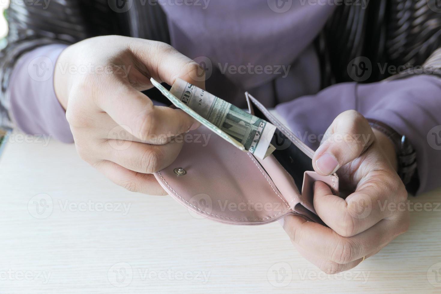 persona poniendo dinero en una billetera foto