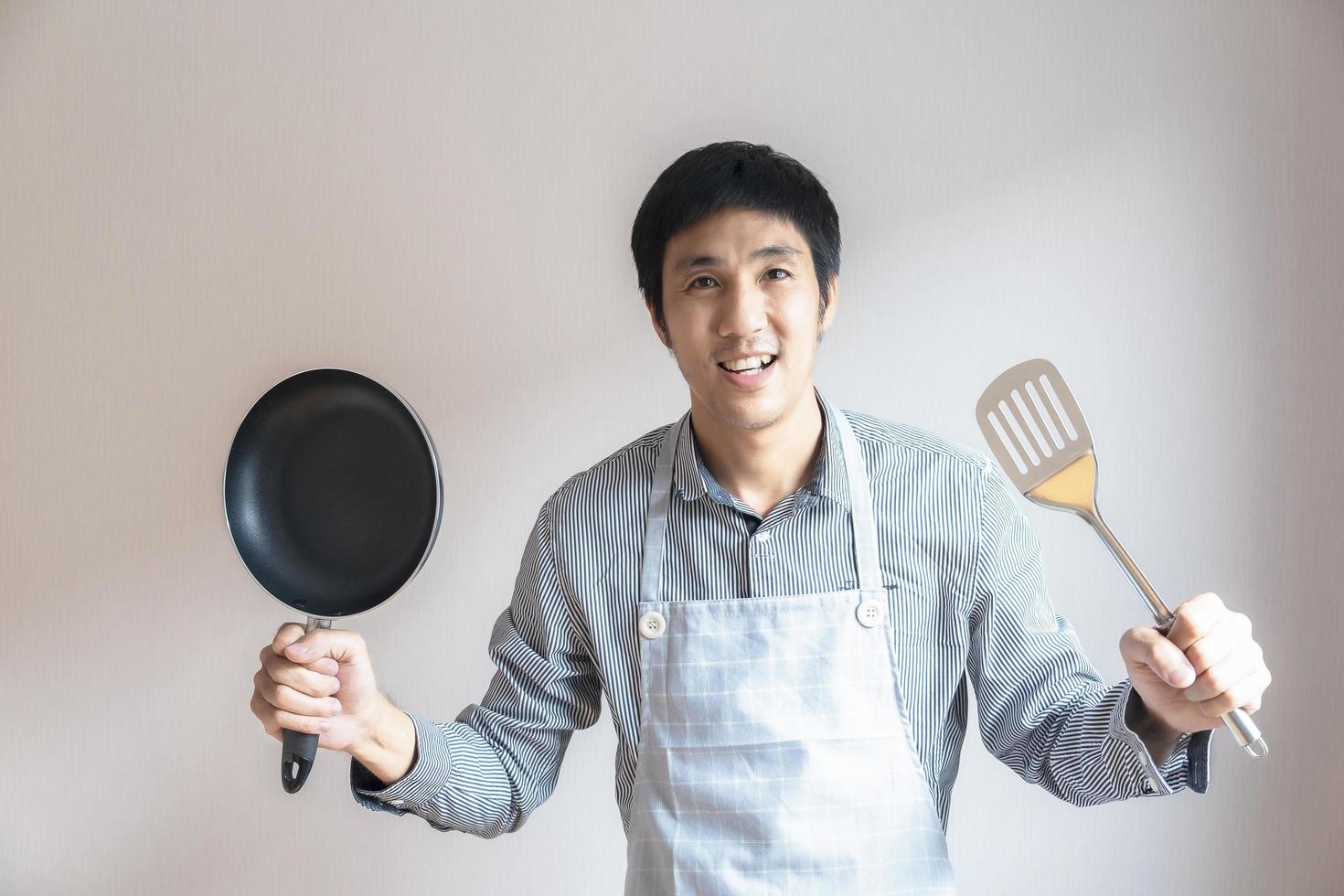 Man holding a pan and spatula photo