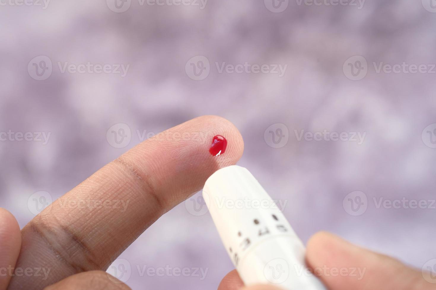 Man's hand measuring a glucose level close up photo