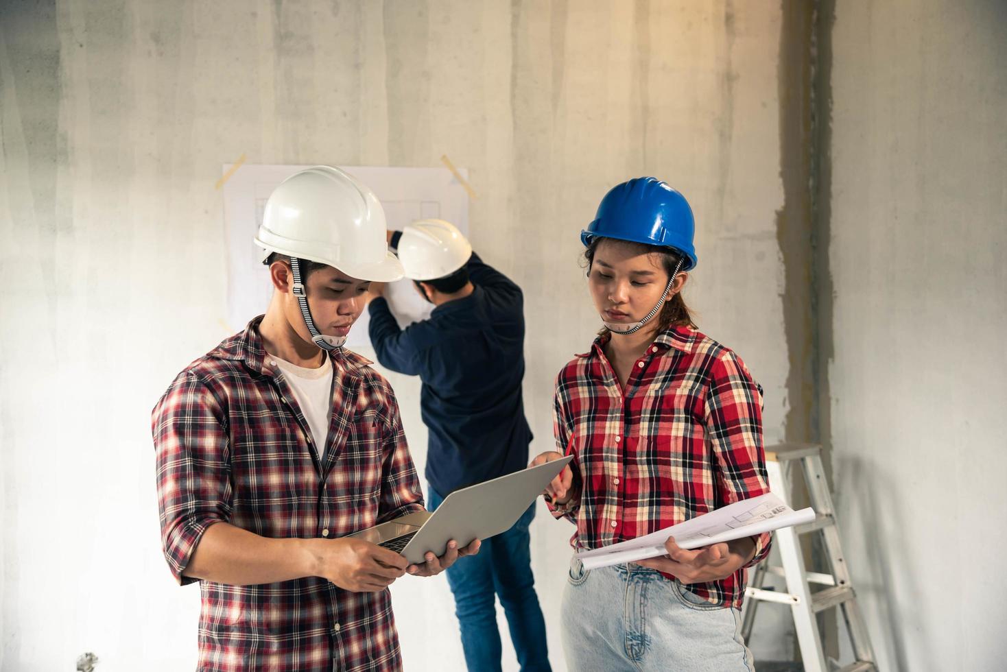 jóvenes ingenieros asiáticos construyendo una casa foto