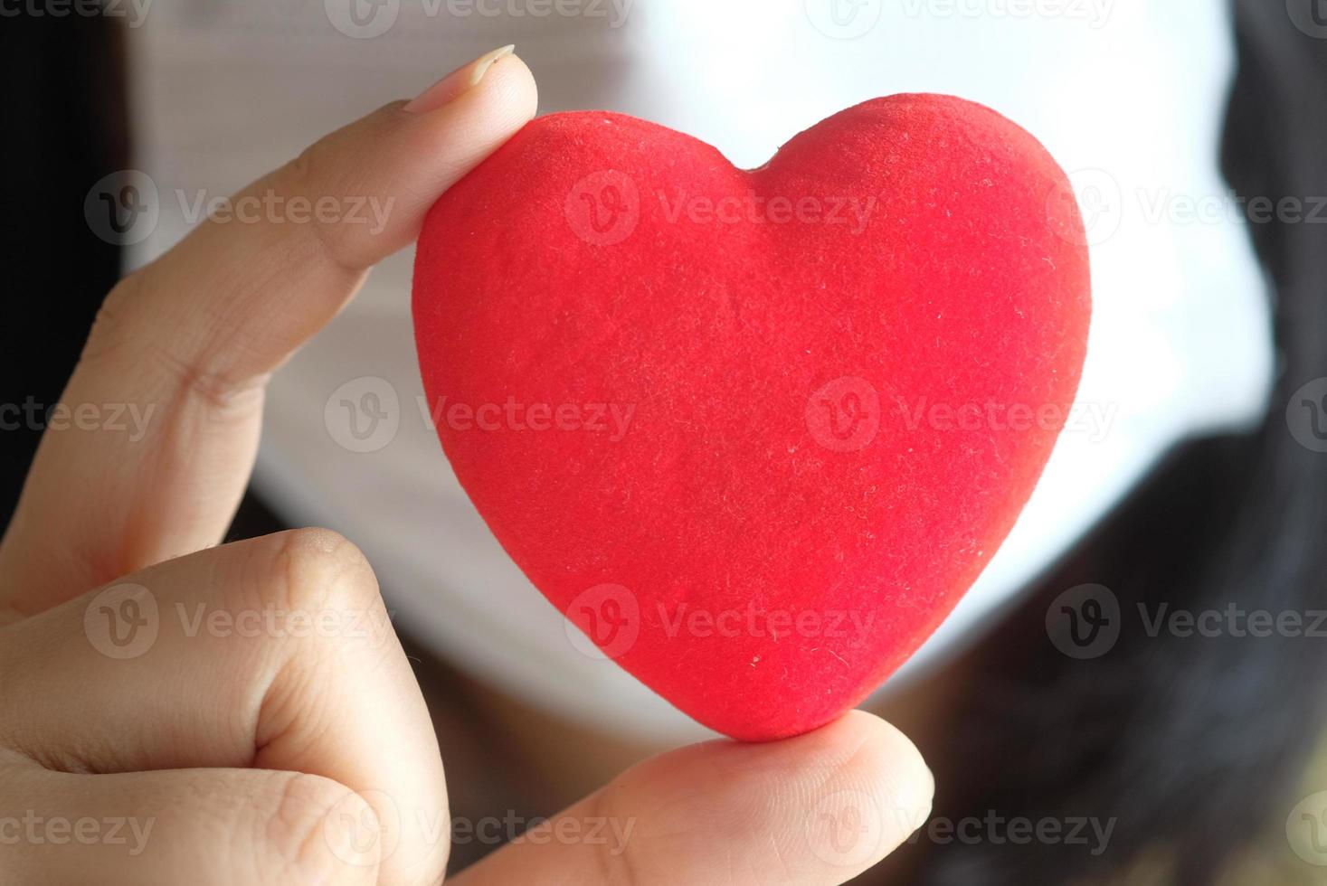 mujeres sosteniendo corazón rojo con espacio de copia foto