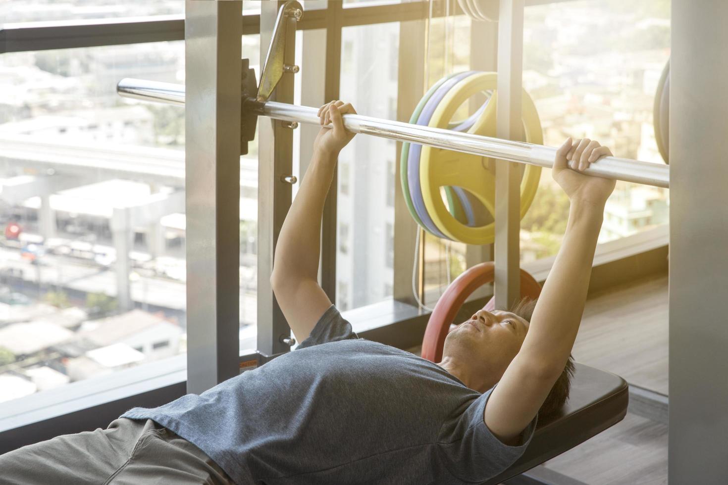 Young man lifting a barbell photo